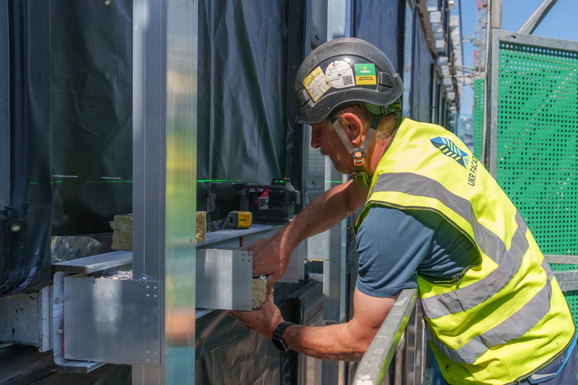 ukr-facades-grand-felda-house-wembley-project-24 UKR Facades operative carrying out detailed installation work on the Grand Felda House facade in Wembley