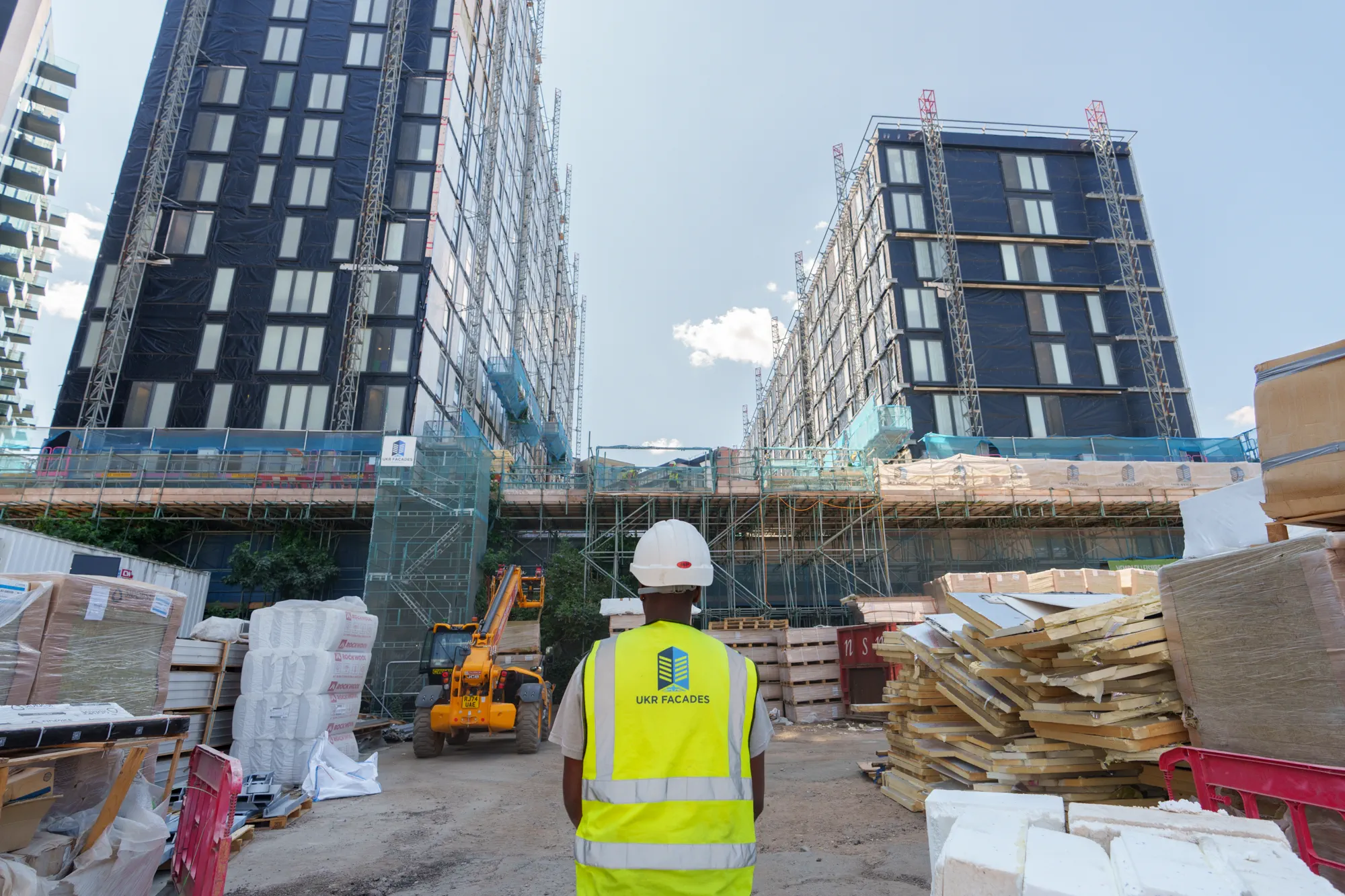 ukr-facades-grand-felda-house-wembley-project-3 Construction site view of Grand Felda House in Wembley with multi-storey residential towers behind