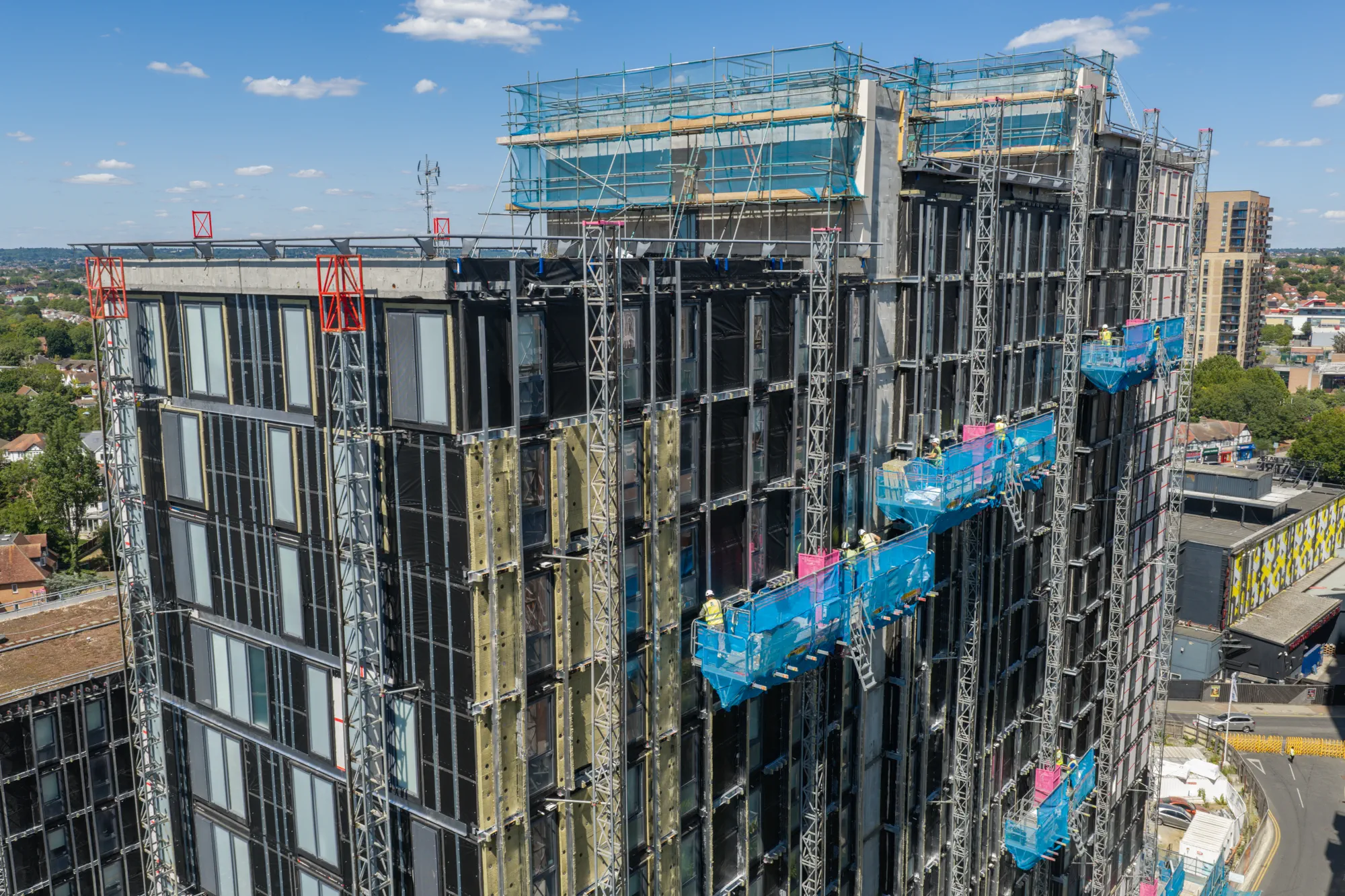 High-rise facade construction at Grand Felda House in Wembley with external access platforms across the elevation