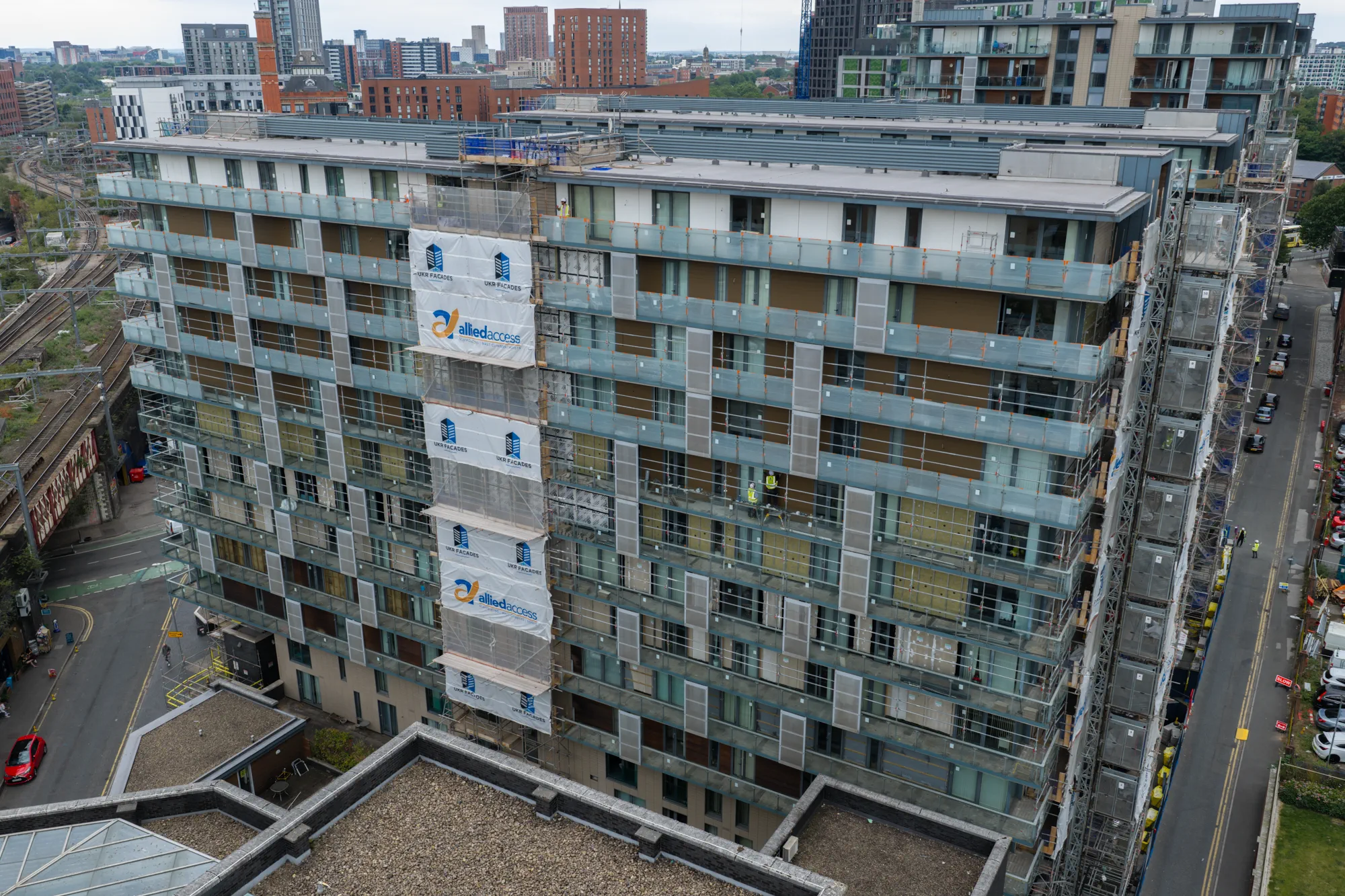 Front aerial view of extensive external facade works at Spectrum Apartments residential development in Salford
