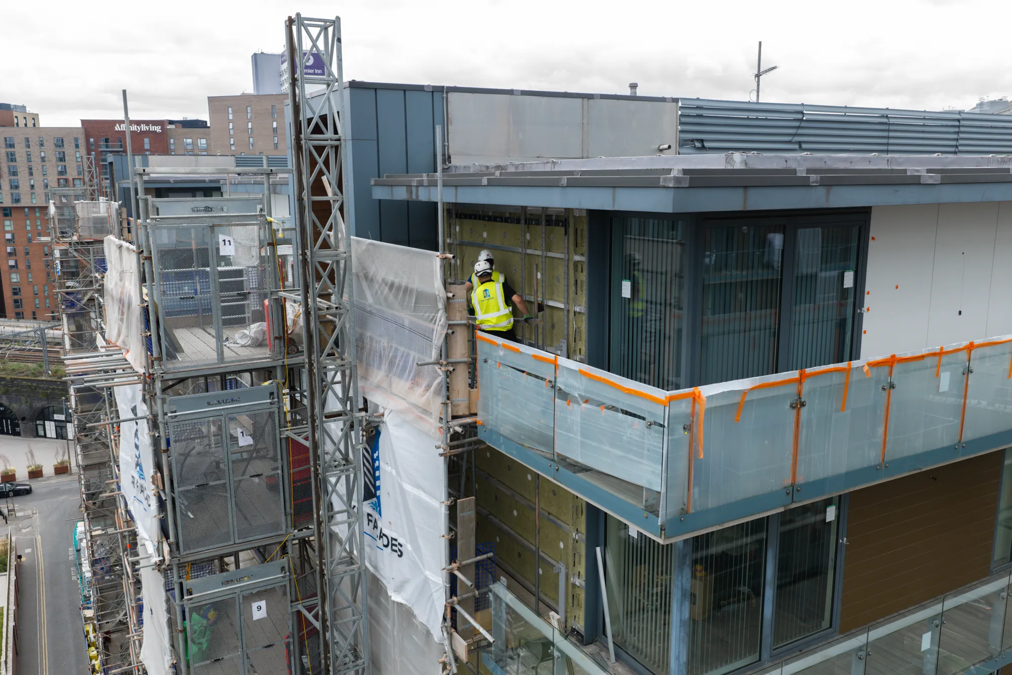 UKR Facades operative working at height around the upper balcony elevation at Spectrum Apartments in Salford
