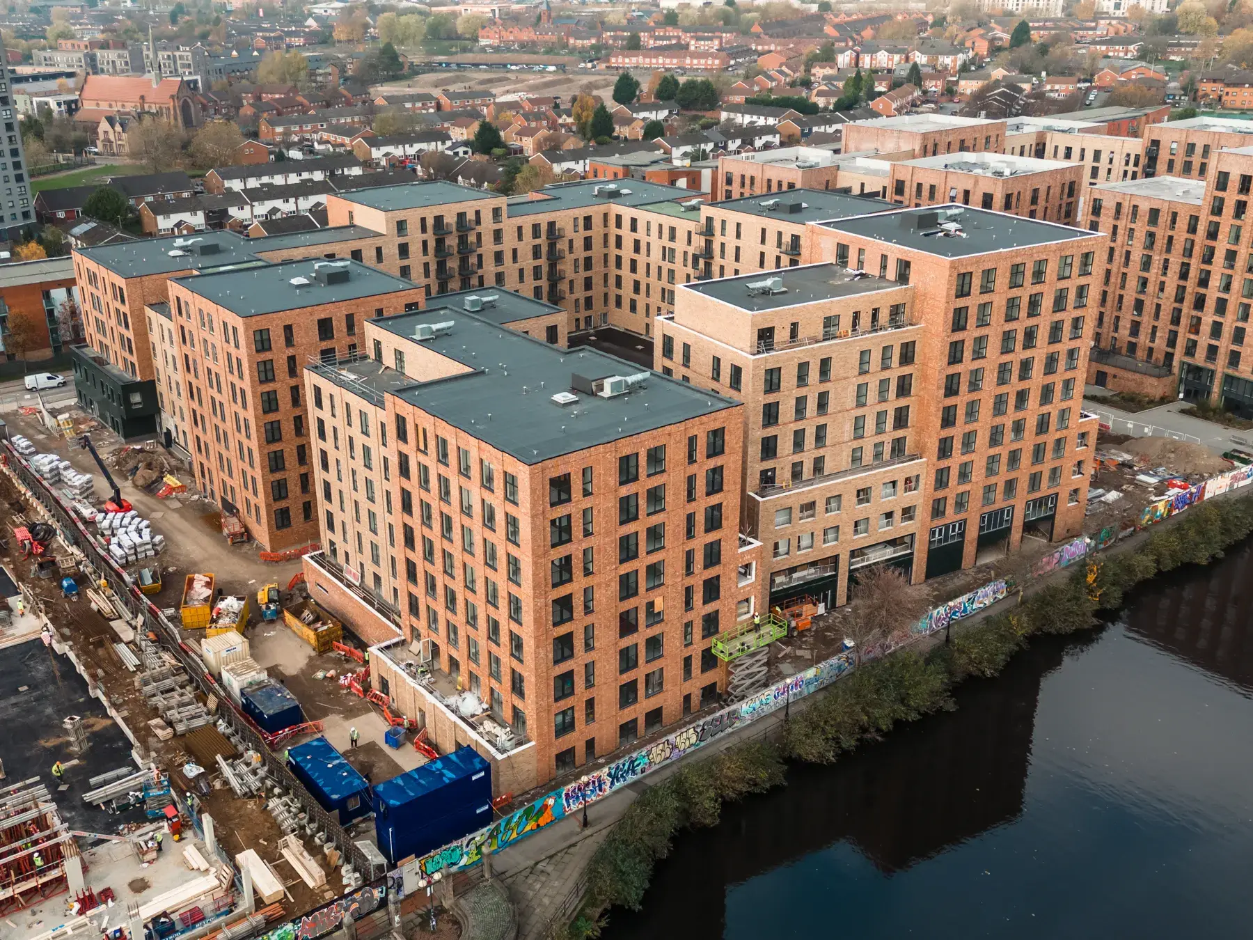 Aerial view of completed Bridgewater Wharf residential buildings beside the River Irwell